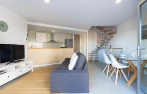 a living room with a couch and a dining room at Modern seafront flat with a private garage in El Médano