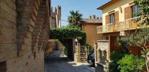 een steegje tussen twee gebouwen met een geparkeerde auto bij Cà La Terrazza in Gradara