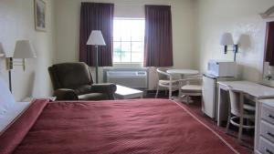 a hotel room with a bed and a desk and chairs at Americas Best Value Inn and Suites Houston FM 1960 in Houston