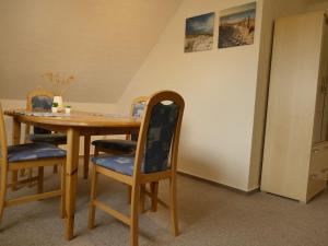 a dining room table with four chairs and a table at Cozy Apartment located in Rovershagen with Garden in Rövershagen