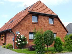 een rood bakstenen huis met een rood dak bij Cozy Apartment located in Rovershagen with Garden in Rövershagen