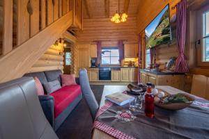 ein Wohnzimmer mit einem Tisch und einem Sofa in einer Blockhütte in der Unterkunft Connys Naturberghütten in Großkirchheim