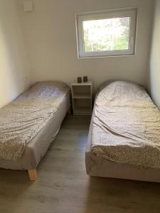 2 Betten in einem kleinen Zimmer mit Fenster in der Unterkunft Sjölanda in Sjuntorp