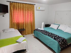 1 dormitorio con 2 camas y ventana en Departamento Bocagrande cerca a playas en Cartagena de Indias