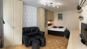 ein Wohnzimmer mit einem Stuhl und einem Bett in der Unterkunft Luxury Studio Apartments in Ljubljana