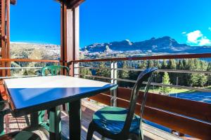 a table and chairs on a balcony with a view at Stunning 3-bedroom apartment with mountain views in Flaine
