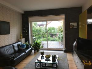 sala de estar con sofá, mesa y ventana en Chambre d'hôtes Le Cadran des Chauvelles, en Nevers