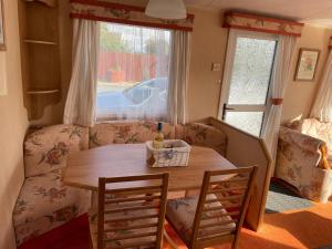 a living room with a table and a couch at Happy Days Holiday Home Whithorn2 in Newton Stewart