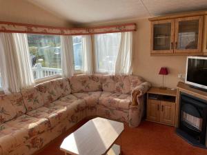 a living room with a couch and a tv at Happy Days Holiday Home Whithorn2 in Newton Stewart