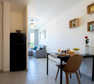 °Le métropole° Check in H24/wifi في ليون: مطبخ وغرفة معيشة مع ثلاجة سوداء