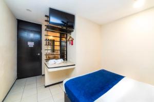 a room with a bed and a flat screen tv at Hotel Kapu, Puebla in Puebla +23 photos