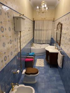niebieska łazienka z wanną, toaletą i umywalką w obiekcie Al Centro Storico Home w mieście Neapol
