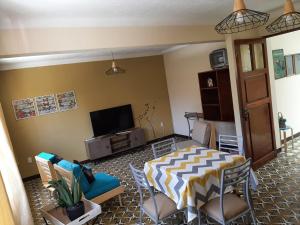 a living room with a table and a tv at Refugio del Turista in Tupiza