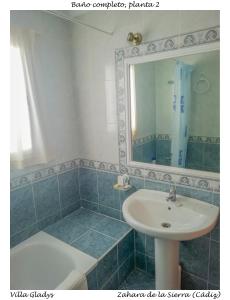 a bathroom with a sink and a mirror and a tub at CASA GLADYS in Zahara de la Sierra