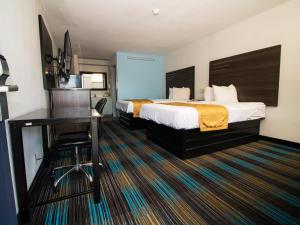 Sweet Dream Inn - University Park في بينساكولا: غرفة في الفندق مع سرير ومكتب