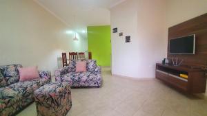 een woonkamer met 2 banken en een flatscreen-tv bij Piscina, Churrasqueira, Bilhar, SmartTV, Wi-Fi, 400mts mar! in Itanhaém