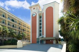 a large building with a clock tower in front of it at Palette Resort Myrtle Beach in Myrtle Beach