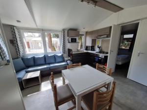 Una sala de estar con un sofá azul y una mesa. en Louons ensemble, en Saint-Jean-de-Monts 14 fotos más