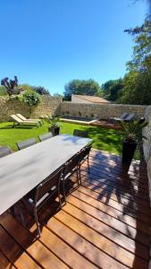 a wooden deck with a table and chairs on it at La Closerie du Château in Uzès