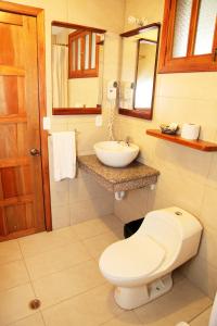 a bathroom with a toilet and a sink at La Floresta Hotel in Baños