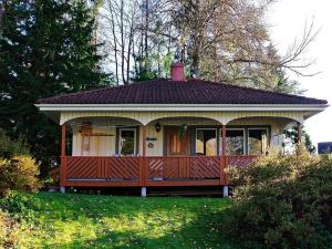une petite maison avec une terrasse couverte sur une pelouse dans l'établissement 2 person holiday home in BENGTSFORS, à Bengtsfors