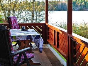 a table and chair on a porch with a view of a lake at 2 person holiday home in BENGTSFORS in Bengtsfors