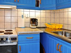 a kitchen with blue cabinets and a counter top at 2 person holiday home in BENGTSFORS in Bengtsfors