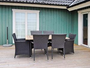 een houten tafel en stoelen op een patio bij Holiday home Osby in Osby