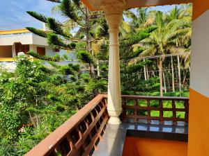 - un balcon d'une maison avec des palmiers dans l'établissement Thriphala Ayurveda Yogashram, à Trivandrum