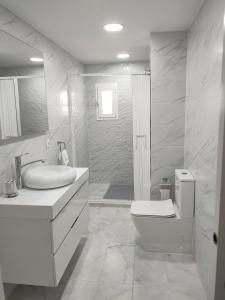 een witte badkamer met een toilet en een wastafel bij Maya in Era de Soler