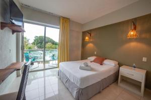 a hotel room with a bed and a balcony at Caribe Princess in Chetumal