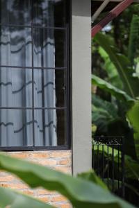 a window of a house with a white curtain at Charmoso studio em Tiradentes in Tiradentes +1 photo