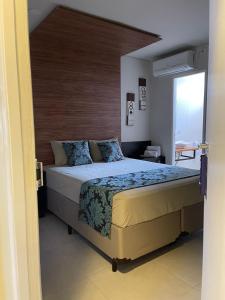 um quarto com uma cama grande e uma cabeceira em madeira em Green It Motel & Hotel em Bragança Paulista