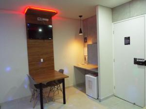 Habitación con mesa y escritorio con ordenador. en Green It Motel & Hotel, en Bragança Paulista