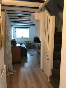 a hallway with a stairway leading to a living room at Rhos cottage Ruthin in Ruthin +10 photos