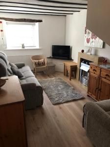 a living room with a couch and a television at Rhos cottage Ruthin in Ruthin