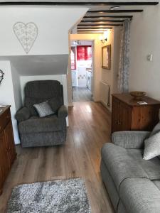 a living room with a couch and a chair at Rhos cottage Ruthin in Ruthin