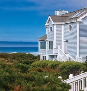 une maison blanche avec l'océan en arrière-plan dans l'établissement Schooner Landing, à Newport