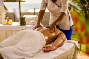 uma mulher a fazer um homem voltar a uma mesa de massagem em Hotel Soleil Pacifico em Chulamar