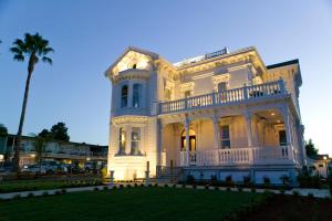 a large white house with a palm tree at West Cliff Inn, A Four Sisters Inn in Santa Cruz