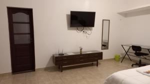 een slaapkamer met een dressoir en een televisie aan de muur bij Departamento temporario con cochera in Resistencia