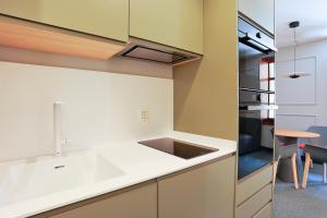 a kitchen with white counters and a sink at Azotea Suites in Ponferrada