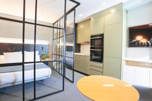 a bedroom with a bed and a tv and a table at Azotea Suites in Ponferrada