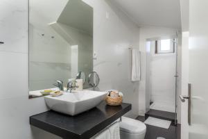 a white bathroom with a sink and a toilet at Carpe Diem Apartments in Porto +52 photos