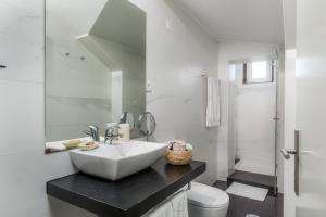 a white bathroom with a sink and a toilet at Carpe Diem Apartments in Porto