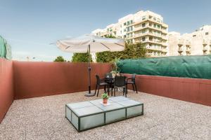 a patio with an umbrella and a table and chairs at Carpe Diem Apartments in Porto