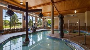 een groot zwembad in een gebouw met een houten plafond bij Best Western Plus Kelly Inn and Suites in Fargo