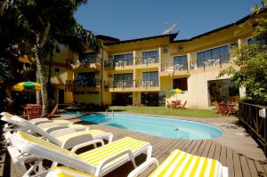 a swimming pool with lounge chairs and a hotel at Pousada Aquarela de Bombinhas in Bombinhas