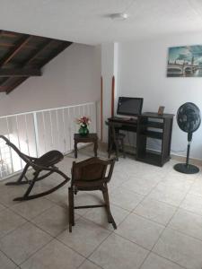 sala de estar con silla y escritorio con ventilador en Hermosa Casa en excelente vecindario en San Gil, en San Gil