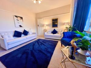 een woonkamer met 2 banken en een blauw tapijt bij A LUXURY DETACHED FIVE STAR 4 bed Victorian home with HOT TUB!! in Panteg